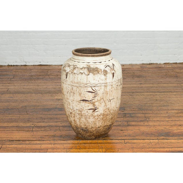 A Thai Sawankhalok exterior water jar from the mid-19th century, with distressed white patina. Created in the kilns of...