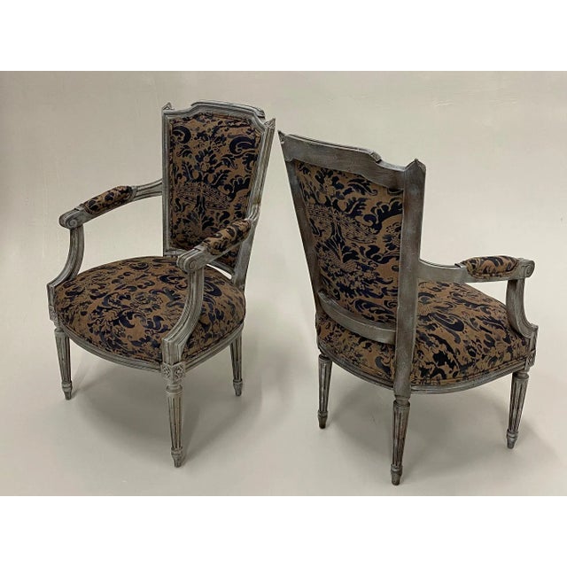 Superb pair of French vintage fauteuil armchairs having painted carved wood frames and wonderful Fortuny upholstery. Arm...