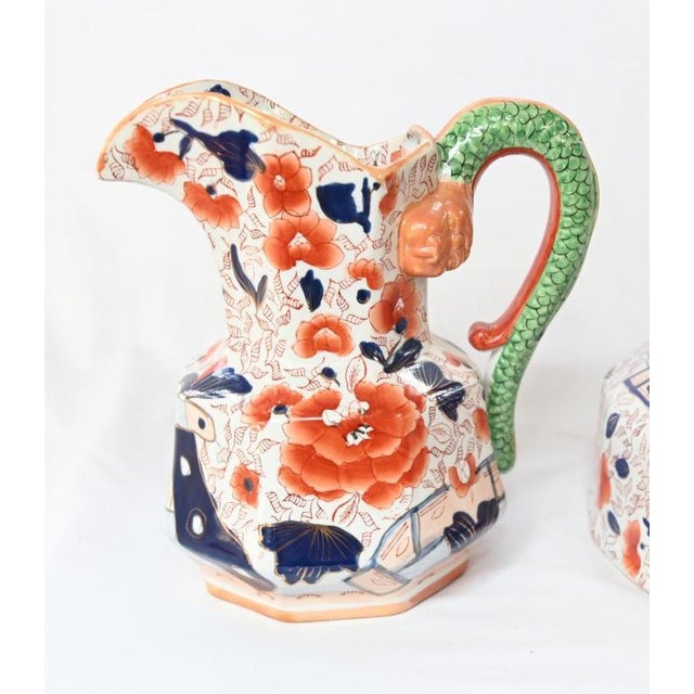 A decorative jug and basin with Imari style floral decoration in iron red and cobalt blue Large blossoms and leafy...
