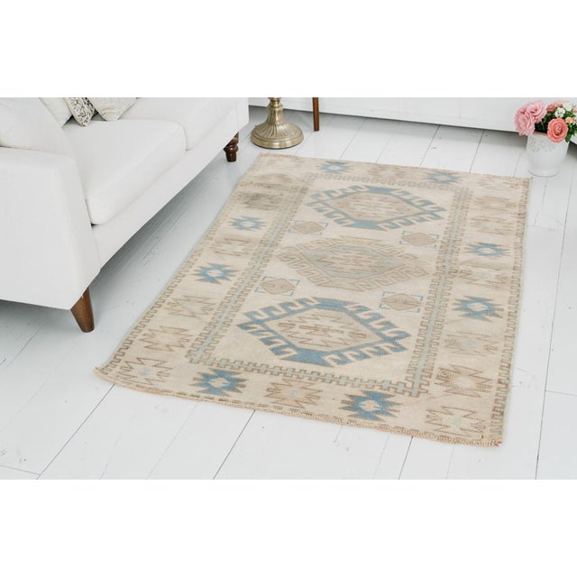 This is a vintage Turkish Oushak rug from the Mid 20th Century. The piece was hand-knotted.