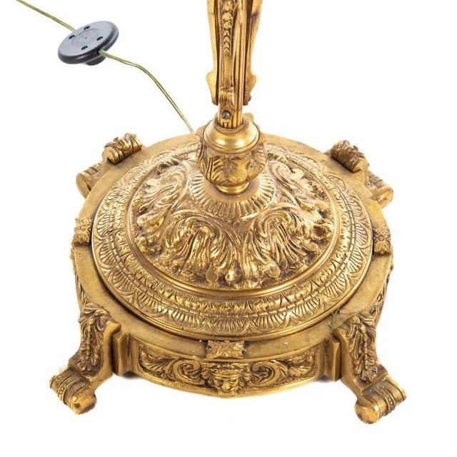 A 20th century; elaborately cast base, with four scroll feet, four lights with frosted glass shades, 68 in. H. Elevate...