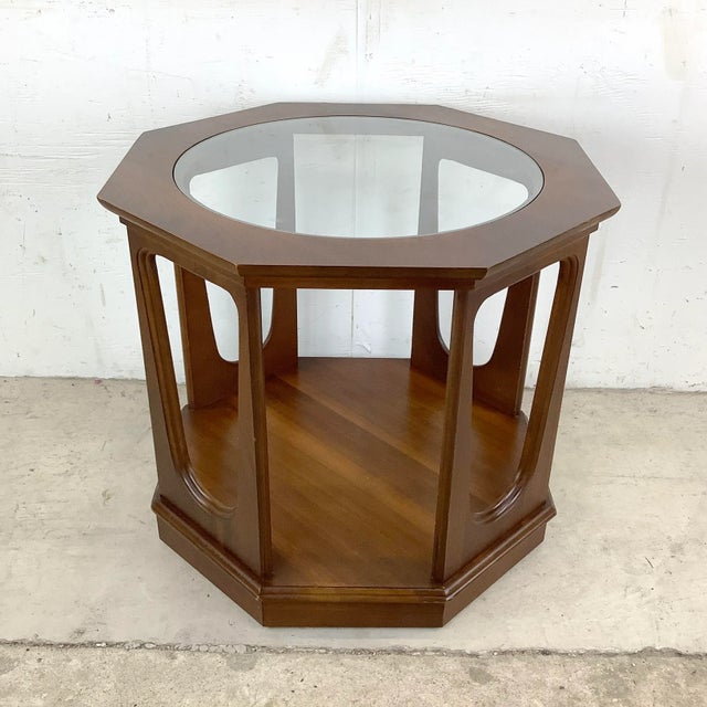 This mid-century modern end table features a sculptural walnut finish with glass top. The octagonal design of this...