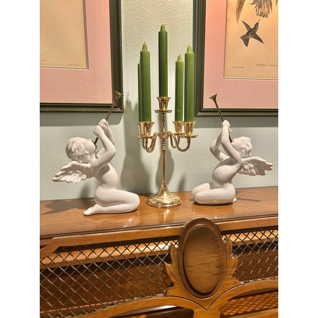 This pair of white porcelain angels are blowing their brass trumpets to signal holiday joy. They were offered by...