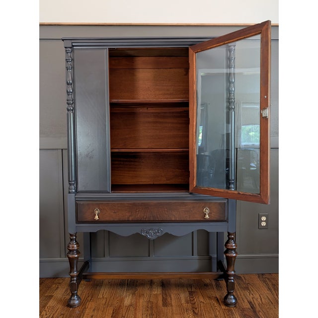 This Jacobean-style hutch is made of solid walnut and walnut veneers and features carved wooden legs, brass hardware, and...