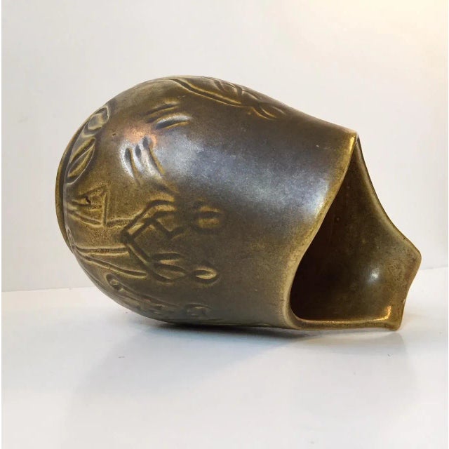 Stoneware vase with an organic shape and a soft pickles green glaze. The body on the vase is incised with human figurines...