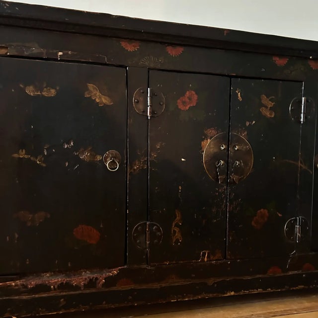 This piece is constructed of solid elm, which has been lacquered in black and adorned with hand-painted motifs. It hails...