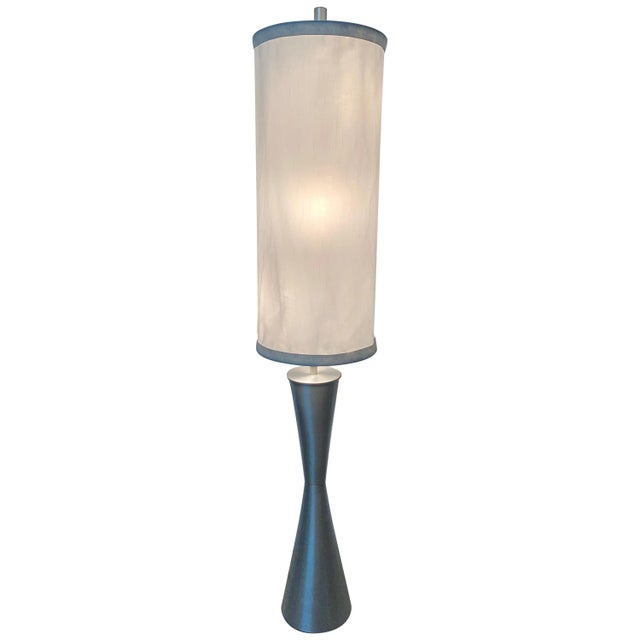 Postmodern geometric sculptural floor lamp rendered in spun aluminum base comprised of two intersecting cones with a...