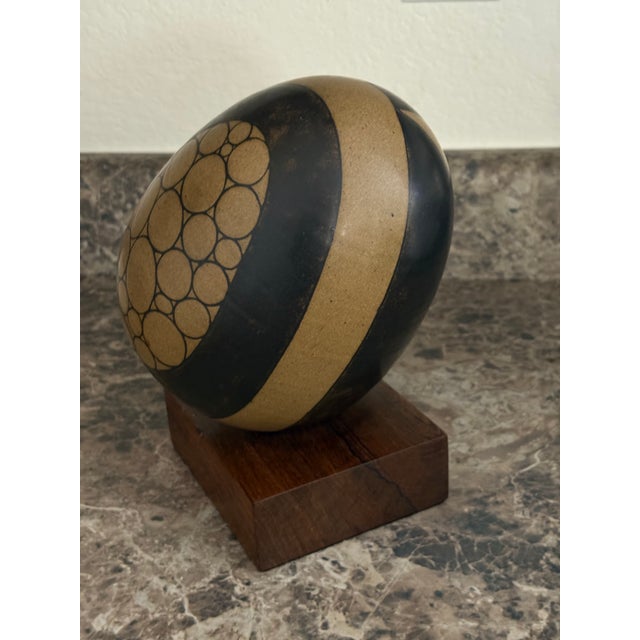 Subtle sophistication with geometric design create this skillful ceramic egg sculpture. The muted tan and black color...