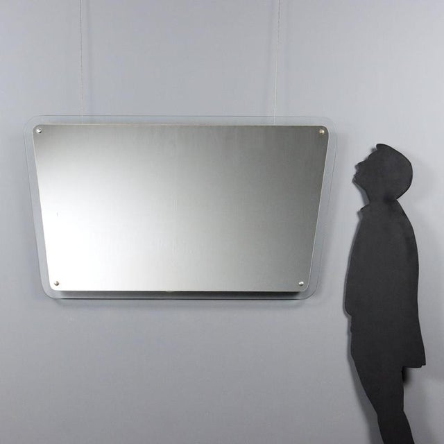 This rectangular wall mirror, made in the 1960s with rounded corners, is typical of mid-century modernism. The thin,...