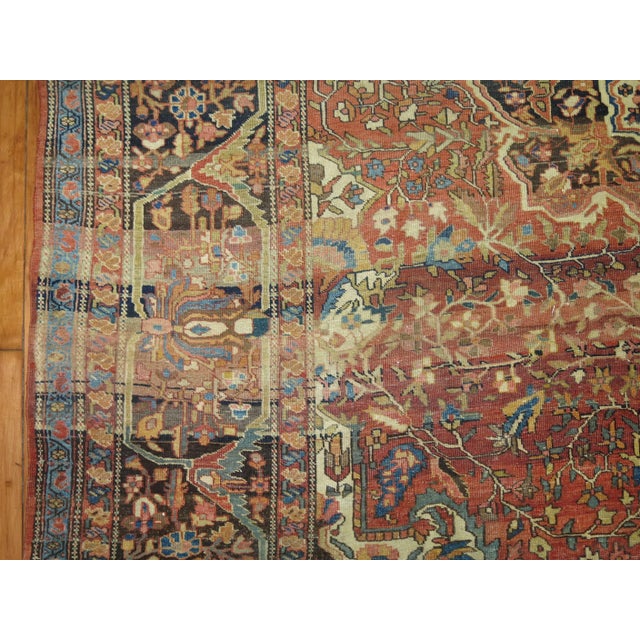 Beautifl abrashes highlight this early 20th century Antique Persian Sarouk Ferehan. Rust Background with pretty shades in...