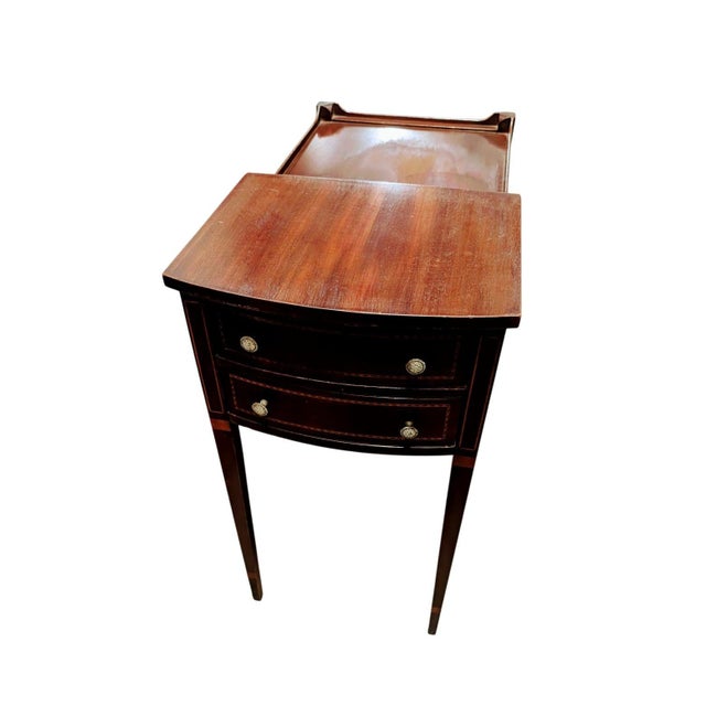 This is a Vintage Mahogany two-tiered side table with 2 drawers, adorned with antique brass knobs. Furthermore, they are...
