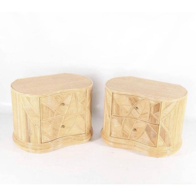 Rare pair of rattan bedside tables with foliages patterns. Raffia top, brass handles, 2 drawers. Great condition and...