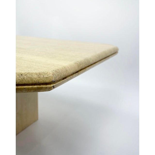 Elegant vintage coffee table from the 1970s, in solid vanilla-colored travertine. The sculptural design features a...
