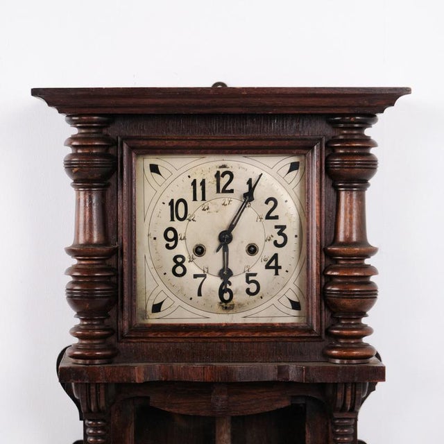 Antique oak wall clock with carved details from the 1920s. Classic wooden wall clock with decorative craftsmanship. —...