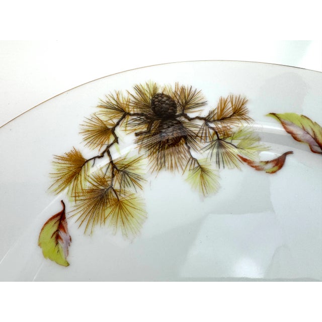 A refined 21-piece collection of Kyoto China in the elegant "Pines" pattern, featuring wispy conifer branches, warm golden...