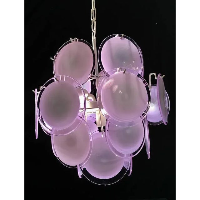 The 24 violet discs of precious Murano glass are arranged on floor levels. Nine lights. Measures: Height without chain 50...