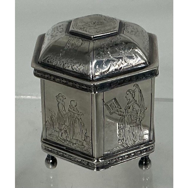 Pretty hexagonal form box with matching lid engraved with pastoral scenes on all sides. Gold wash interior, raised on 3...