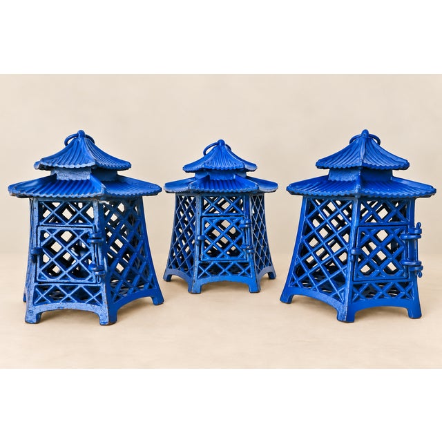 Offered is a fabulous set of three blue vintage pagoda laterns. Made from cast iron, the doors easily open to insert a...