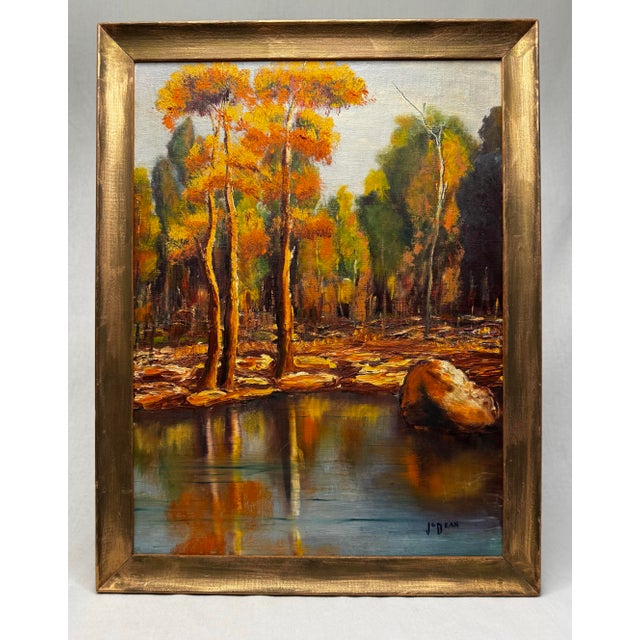 This original, vintage oil landscape painting on canvas board depicts a serene autumn scene featuring a cluster of tall,...