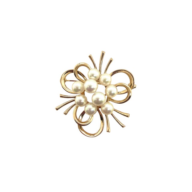 A fine 14K Gold Mikimoto pearl brooh, Circa 1960. The brooch is in the modernist style with a cluster of pearls centered...