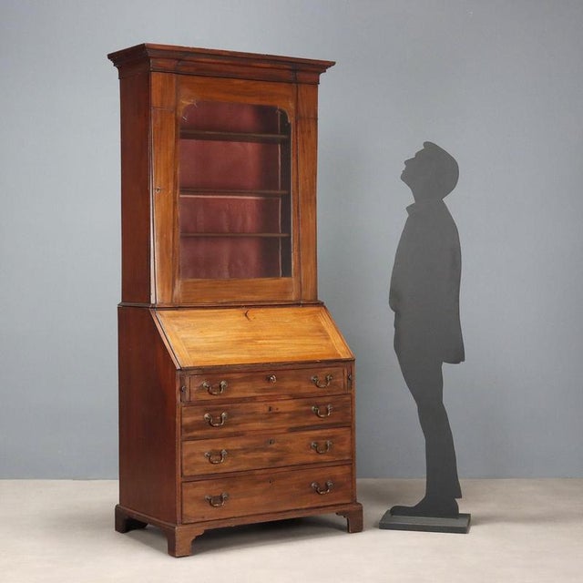 Mahogany trumeau. Stand with beveled glass door and molded top, three height-adjustable shelves inside. Central drop-down...