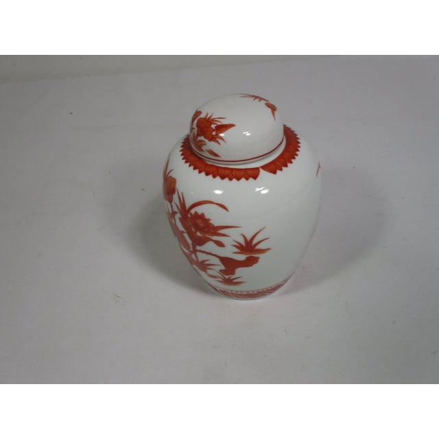 This vintage porcelain Chinese ginger jar is hand decorated in red Lotis designs on a white background. It would be a...