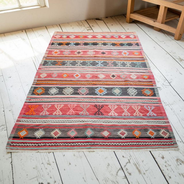 Originating from the Aegean region of Anatolia, this striking 1960s vintage Balikesir kilim is a remarkable example of...