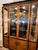 Original glass front chinoiserie style tall display cabinet by Century Furniture Co. It's made with wood, burl, and black...