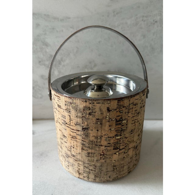 Vintage ice bucket by Kim Seybert Bar. featuring a silver metal lid and handle and cork wrapped bucket with gold fleck...