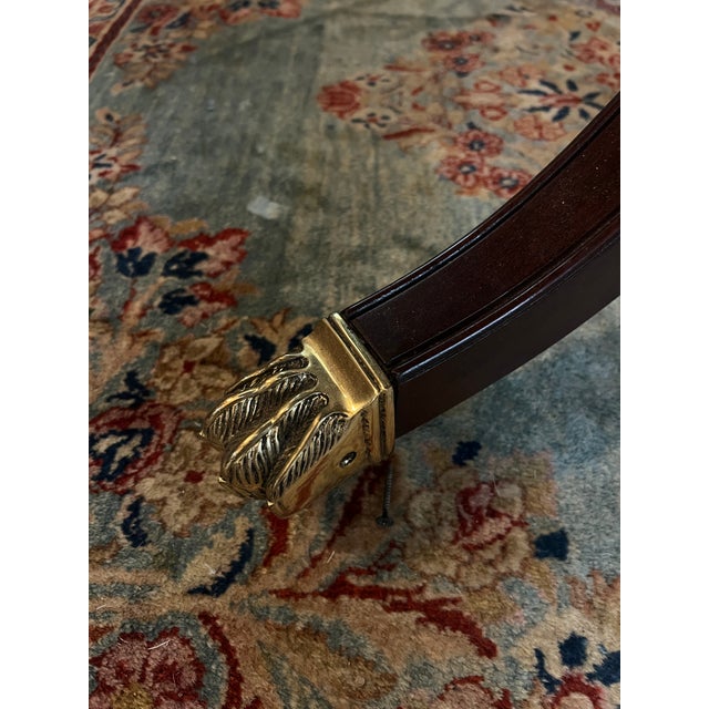 This is a Regency Style Mahogany Dining Table with Inlaid Star. It is an extension table with brass paw feet on rollers....