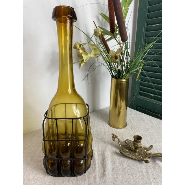 Magnificent glass bottle encased in wrought iron. Italian production from the 1930s (probably Murano). Beautifully...