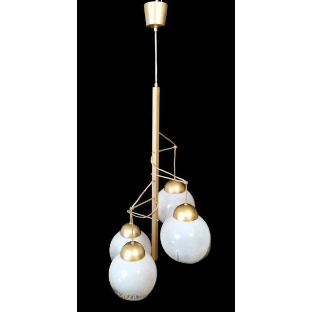Original and peculiar chandelier executed in the Space Age style; the structure is composed of a solid bar of satin-...
