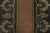This antique 3x4 hooked rug, circa 1920–1929, features a restrained floral border design in warm terracotta, olive, and...