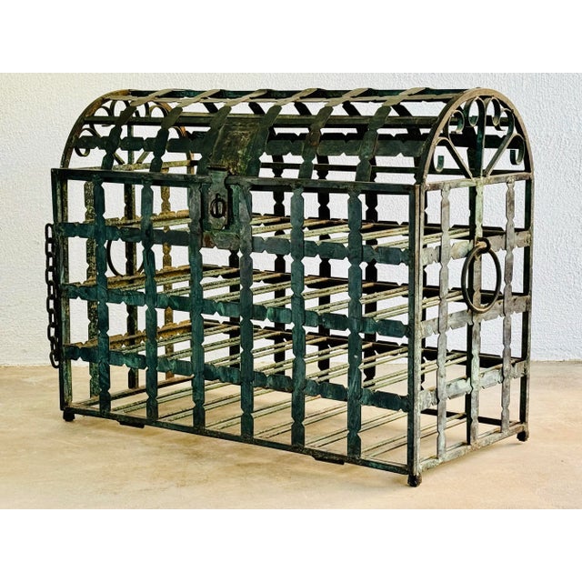 A steel wine rack with front hinged opening. The welded steel cage is in the form of a dome top chest. Two ring handles...