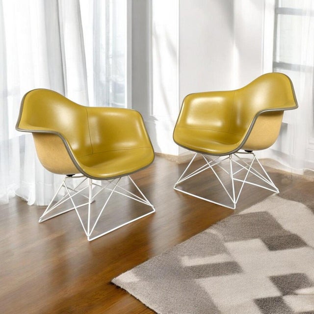 Incredibly rare pair of eames for herman miller lar lounge chairs with yellow naugahyde pads. The chairs both have their...