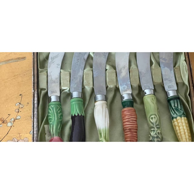 Vintage set of cheese knives with ceramic handles in the shape of vegetables.