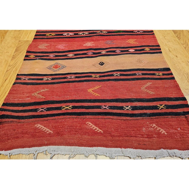 This striking vintage Turkish kilim runner, handwoven in Anatolia during the mid-20th century, embodies the artistry and...