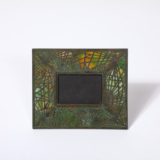 This striking Tiffany Studios Bronze & Favrile Slag Glass Pine Needle Pattern Picture Frame originated in the United...