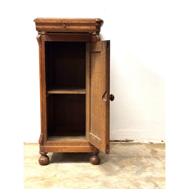 Tucked into the quiet corners of a 19th-century English home, this oak pot cupboard would have stood faithfully beside a...