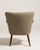 A refined Danish armchair featuring a shellback form, reflecting early Scandinavian modern design. The curved back...