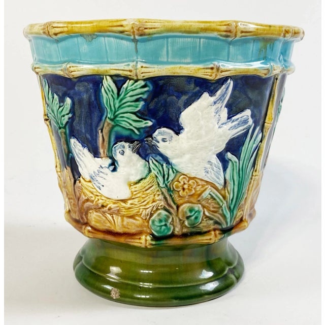 Vibrant antique Majolica jardinière featuring raised relief faux bamboo rim and frames with four dividing images on a rich...