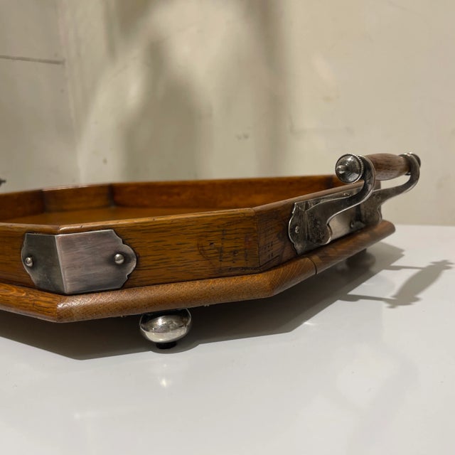 A nice late 19th century English oak serving tray with Silverplated ball feet, corner plates, and handle supports, with an...