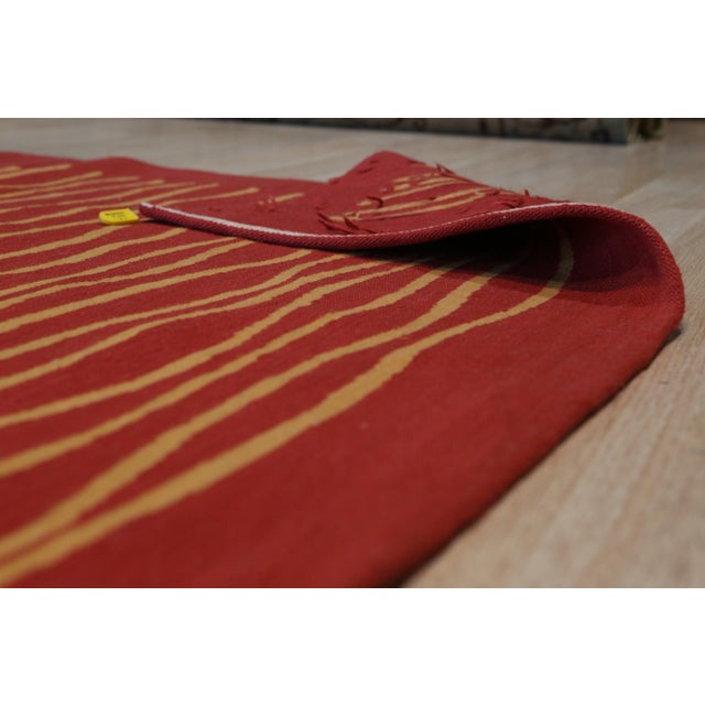 A handwoven wool flatweave, made in India and measuring 6' x 8'. Geometric drawing - repeating motifs held inside strong...