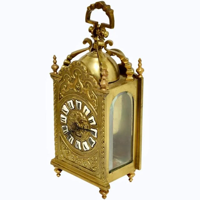 A decorative and versatile brass carriage clock, with inset enamel face numerals. Lovely cast detail frames the face, with...