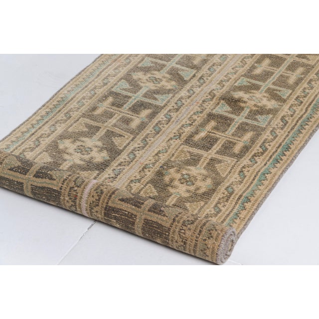 This is a vintage Turkish Oushak rug from the Mid 20th Century. The piece was hand-knotted.