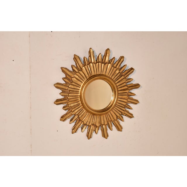Mid-20th century modern hand carved sunburst mirror from France. This mirror is stunning, and has a great profile from the...