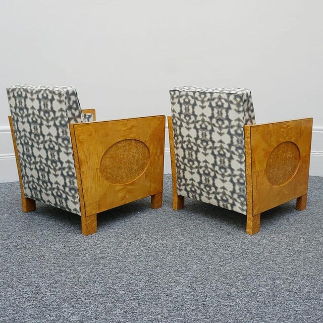 A pair of art deco club chairs. Satin birch veneered sides with an oval karelian birch detail. Karelian birch and ebonised...