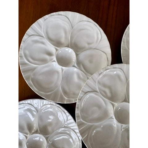 Set of six white porcelain oyster plates by Pillivuyt, France. Each plate with six oyster wells surrounding a central well...