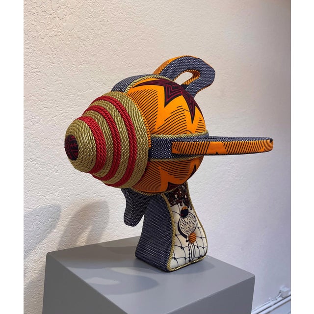 Ray Gun 56 features a playful yet intricate design, combining wood, foam, and fabric to create a whimsical representation...