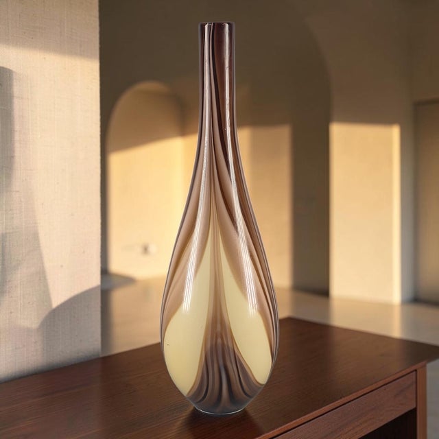 This stunning 22'' vase is a hand-blown piece of art glass with an abstract pattern in earth tones. Originating from...